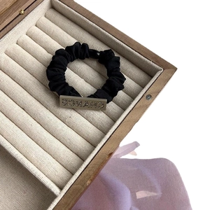 Elegant black scrunchie with gold metal plate featuring CHANCE rhinestone lettering