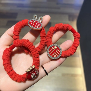 Detail of red fabric scrunchies with gold福 charms and sparkling crystal bunny ornaments