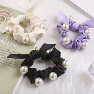 Detail von Satin-Perlen-Haargummis in Cremeweiß, Lavendel und Schwarz mit Schleifenbändern