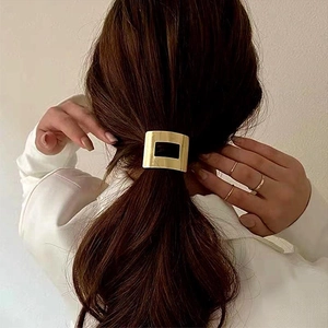 Elastico per capelli minimalista in metallo dorato per coda bassa indossato da modella