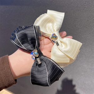 Detailed view of handmade bow hair clips with lace trim and sparkling heart crystal accents