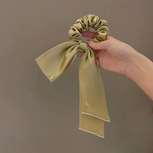Elegant satin scrunchie with long bow ribbon and pearl trim decoration in soft green
