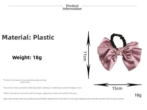 Detail view of pink satin bow hair scrunchie with metal tube detail on white background