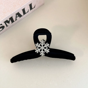 Detailed view of large black flocked shark clip with shimmering silver snowflake and rhinestones