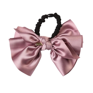 Elegant oversized pink satin bow hair tie with golden metal tag and black elastic band