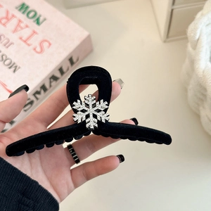 Detail of a large black velvet shark hair claw with a sparkling silver snowflake
