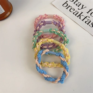Detail of colorful braided hair ties in five macaron shades with matte plastic connectors