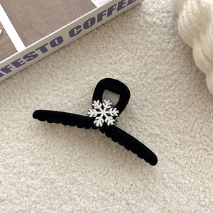 Winter black velvet hair claw clip with crystal snowflake detail on plush background