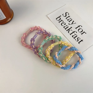 Detailed macro view of five macaron colored elastic braided hair ties with matte buckles