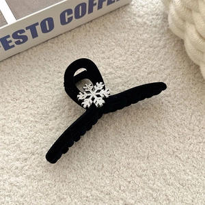 Close-up of black flocked hair claw featuring a silver rhinestone snowflake design