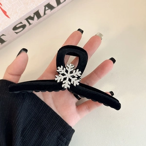 Close-up of black flocked hair claw clip with a sparkling silver snowflake rhinestone detail
