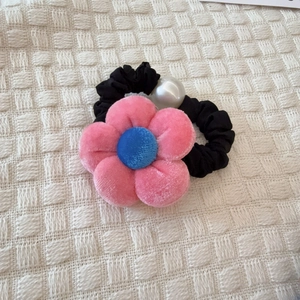 Detalle de coletero con flor de terciopelo rosa, perla blanca y elástico negro suave