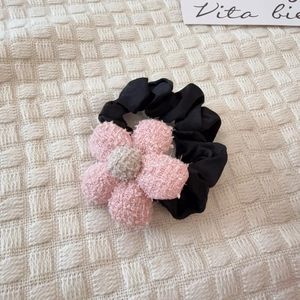 Detalle de lazo para el pelo con flor de felpa rosa y scrunchie elástico negro para niñas