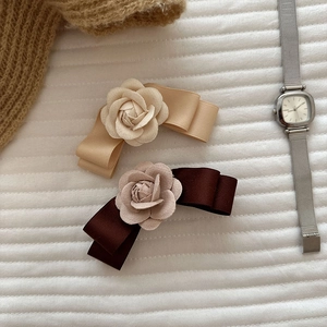 Elegant camellia bow hair clips in champagne and brown satin for a chic vintage hairstyle