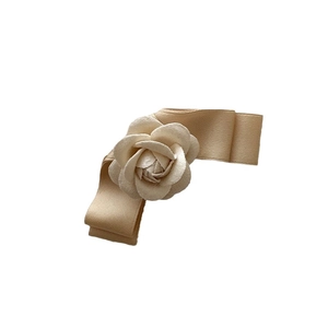 Elegant champagne gold camellia flower hair clip with a silky bow and satin petals