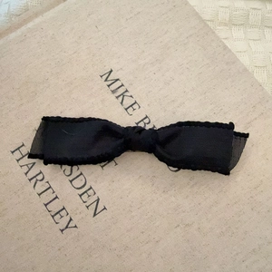 Elegant black bow hair clip with ribbed texture and sheer mesh trim for women