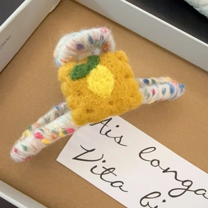 Détail de la pince à cheveux artisanale en feutre jaune avec motif citron mignon