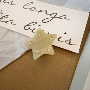 Primer plano de pinza de pelo estrella en resina con textura de mármol y cristales