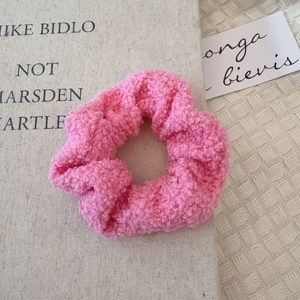 Gros plan du chouchou en peluche rose avec texture douce sur un fond minimaliste