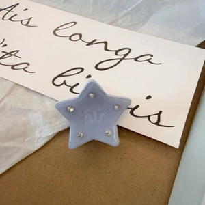 Detalle de una pinza para el pelo con forma de estrella azul cielo y strass incrustados