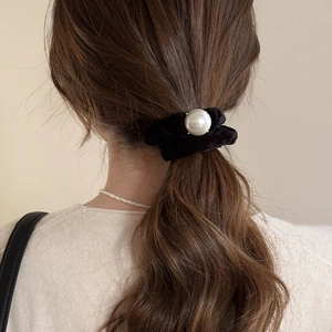 Black velvet hair scrunchie with large pearl accent styled on wavy brown hair