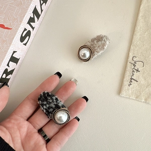 Detail of tweed hair clips with faux pearls and vintage metallic accents for women
