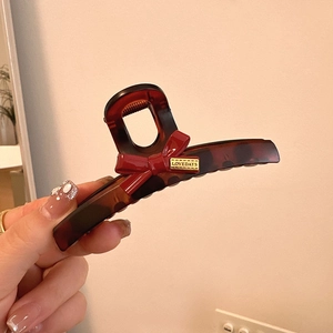Grande molletta per capelli a guscio di tartaruga con fiocco rosso e logo dorato