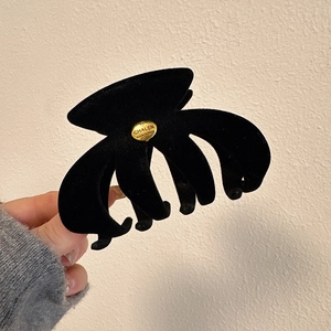 Classic black velvet hair claw clip with golden metal label for stylish updo hairstyle
