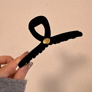 Classic black velvet hair claw clip with a round gold metal emblem for women's hair styling