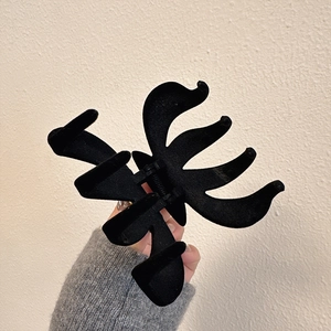 Classic black velvet claw clip with gold label design for elegant updo hairstyles