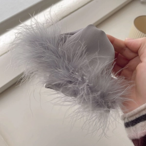 Elegant grey faux feather claw clip with soft fluffy texture for a stylish French hair look