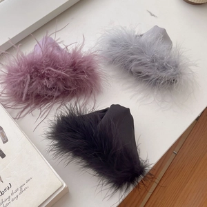Detailed view of luxury feather hair claws in purple, grey and black satin fabric