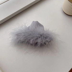 Detail view of the soft grey feather hair claw clip with luxurious silk texture and fluffy plumes