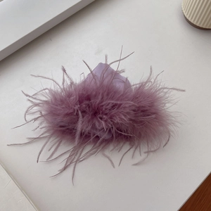 Detailed view of the soft purple ostrich feathers on a luxurious fabric hair claw clip