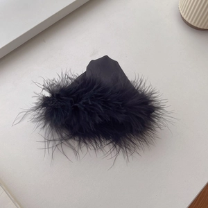 Detail of elegant black feather trim on a minimalist triangle shark hair claw clip