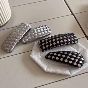 Detail of woven checkerboard hair clips in black and silver vintage minimalist style