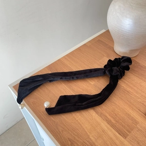 Detail of vintage black velvet hair scrunchie with long ribbons and pearl pendants