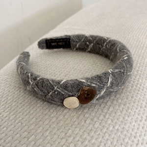 Detailed macro view of gray knitted headband texture with buttons and handmade label