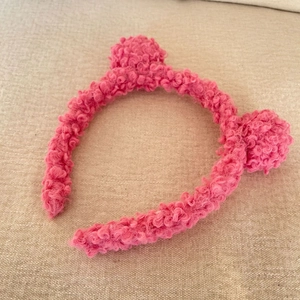 Close-up of pink fuzzy teddy bear ear headband with soft plush lamb wool texture