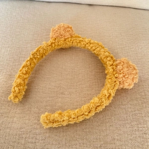 Detailed texture of ginger yellow plush cat ear headband made of soft fleece material