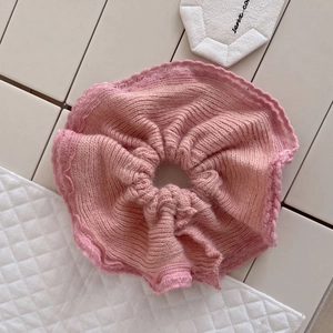 Detailed close-up of a pink mink hair knitted scrunchie with soft wavy edge texture