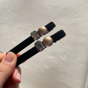 Detailed close-up of vintage black velvet hair clips with champagne pearls and grey crystals