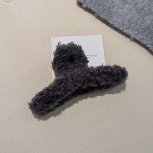 Detailaufnahme einer dunkelgrauen Plüsch-Haarklammer mit weicher Lammfell-Textur