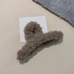 Detailansicht der mokkafarbenen Plüsch-Haarklammer auf weichem beige Hintergrund
