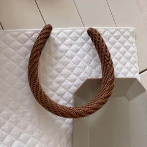 Détail du bandeau en maille marron avec motif torsadé et étiquette Hand Made