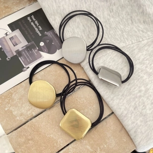 Detailed view of 4 high-elasticity hair ties with gold and silver geometric metal accents