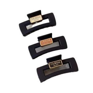 Three-piece set of matte black acrylic shark hair claws featuring Panda Milano lettering