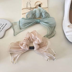 Close-up of elegant organza bow hair scrunchies with rhinestone and handmade label