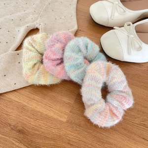 Set of four plush mohair scrunchies in pastel macaron colors on a wooden background