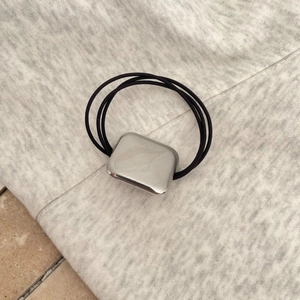 Minimalist elastic hair ties featuring a brushed silver oval metal slide on black cords